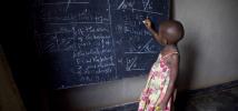 Ecolière devant un tableau noir dans une salle de classe de Kigali, Rwanda. Photo : Simon Rawles