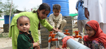 Children washing their plates at an Oxfam water point, Swat valley, Pakistan