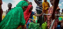 People gather around an Oxfam provided water tank in Hariso, Ethiopia, which provides 10,000 cubic metres of water a day.