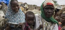 Amina*, 55, a mother of 12, stands with her children outside their hut in the village of Toumour in north eastern Niger, on September 6, 2016. Photo: Pablo Tosco/Oxfam
