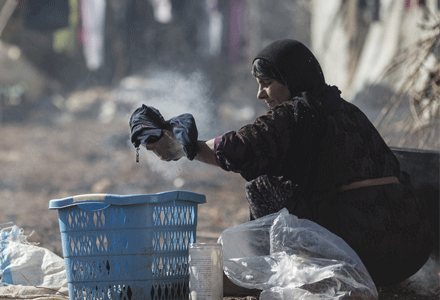 Basterna, 40, from Raqqa in Syria washes clothes by hand at an informal settlement for Syrian refugees near the town of Baalbek in Lebanon's Bekaa Valley, on January 26, 2016. Credit:Sam Tarling