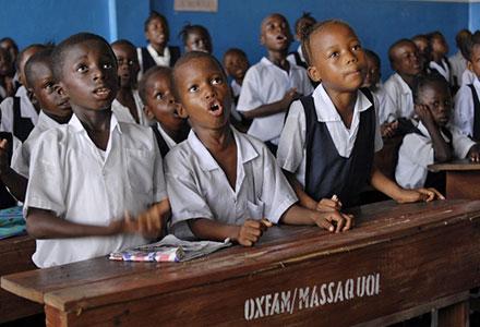 Emanuel Kun (7 años), Nush Gunror (5 años) y Kumba Lamie (8 años) Durante su clase de "letras y números" (preescolar) en la escuela N. V. Massaquoi, en West Point, Monrovia (Liberia). Fotografía: Aubrey Wade/Oxfam